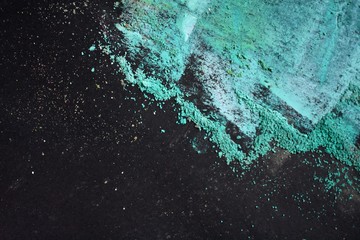 Colorful chalk aqua dust on black paper