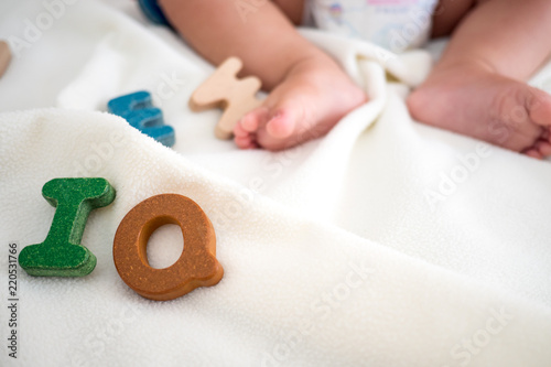 Fotografía IQ text wooden word on blanket with blurred kid foot and copy space background,