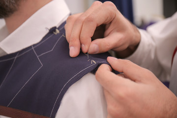 Wall Mural - Tailor working on custom made suit in atelier, closeup