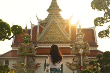 Wall Mural - Woman tourist is sightseeing most famous two giants gate inside Wat Arun in Bangkok, Thailand.