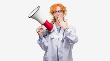 Poster - Young redhead doctor woman holding megaphone cover mouth with hand shocked with shame for mistake, expression of fear, scared in silence, secret concept