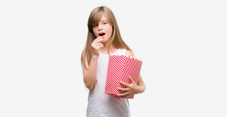 Sticker - Young blonde toddler holding popcorn pack with a confident expression on smart face thinking serious