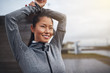 © Flamingo Images - Young Asian woman smiling and stretching before a run