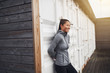 © Flamingo Images - Young Asian woman leaning on a wall outdoors before jogging