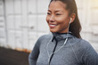 © Flamingo Images - Smiling Asian woman listening to music before a run