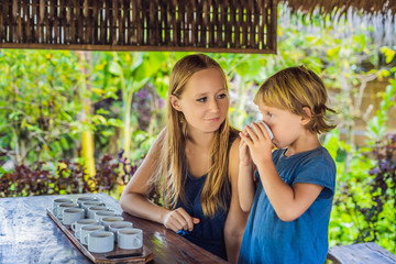 Mom and son are tasting different kinds of coffee and tea, including coffee Luwak