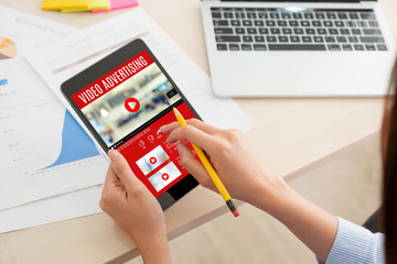 Aufkleber - Shoulder view of woman watching video online with advertising on digital tablet computer at home.viral influencer media concept.