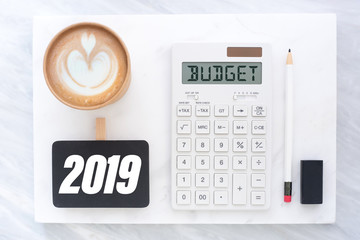 Poster - Top view of new year 2019 budget on calculator and coffee cup on white marble block and stack on grey marble table.financial planning.