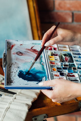 Poster - art painting hobby. creative lifestyle. artist mixing watercolors preparing to draw picture. ink dyes colorful palette. talent inspiration creation and self expression concept