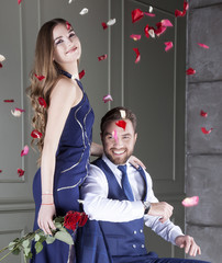 Wall Mural - Happy young couple with roses. Well dressed handsome man and beautiful woman indoors