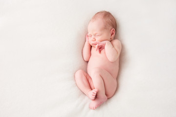 Funny newborn baby sleeping peacefully naked. Top view