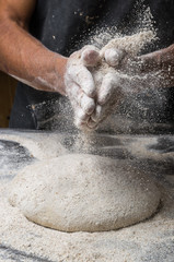 Male hands kneading dough on sprinkled