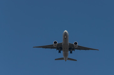  Passenger airplane flying on blue sky background is preparing to land