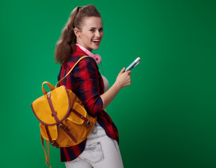 Wall Mural - happy student woman with big pen isolated on green background