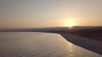 Wall Mural - Tramonto oltre la silhouette delle montagne controluce in riva al mare. Vista aerea.