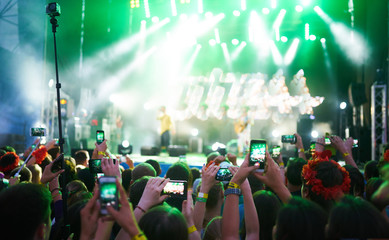 Use advanced mobile recording, fun concerts and beautiful lighting, Candid image of crowd at rock concert, Close up of recording video with smartphone, Enjoy the use of mobile photography.