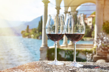 Wall Mural - Two wineglasses. Varenna town at the lake Como, Italy