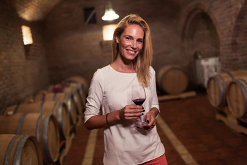 Beautiful woman oenologist tasting wine