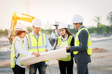 Female engineer at a construction site looking at blueprints