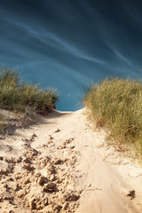 Wall Mural - View of the danish sand dunes cliff in beautiful summer light conditions with the ocean overview. Rubjerg Knude Lighthouse, Lønstrup in North Jutland in Denmark, Skagerrak, North Sea