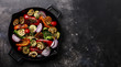 © The Picture Pantry - Grilled assorted vegetables in cast iron pan on dark background copy space