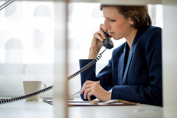 Businesswoman or manageress talking on a landline phone