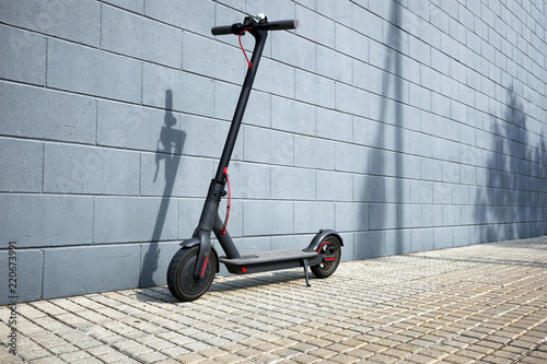 Fotografía electric scooter near blue concrete wall