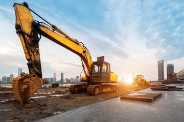 Wall Mural - excavator in construction site on sunset sky background