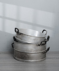 Old stainless steel steamer pot against gray wall background,original style Thai cooking