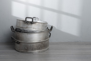 Wall Mural - Old stainless steel steamer pot against gray wall background,original style Thai cooking