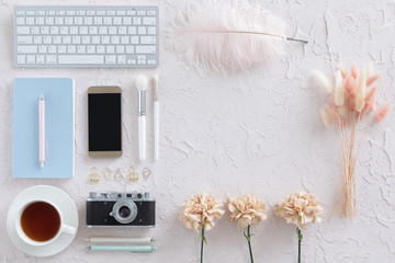 Wall Mural - Top view of woman workspace with laptop, beige flowers, smartphone on white textural background, flat lay. Stylish female blogger concept.