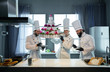 © razoomanetu - Three chefs with a huge cake, mouths in cream