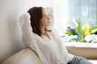 canvas print picture - Relaxed calm woman resting breathing fresh air feeling mental balance enjoying wellbeing at home on sofa, satisfied young lady taking pleasure of stress free weekend morning stretching on couch
