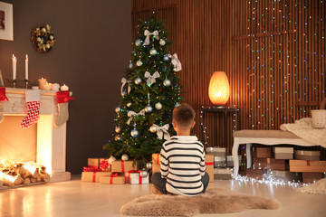 Canvas Print - Cute little child sitting near Christmas tree at home