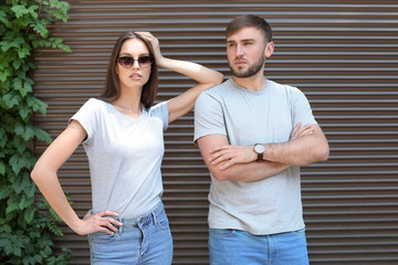 Sticker - Young couple wearing gray t-shirts near wall on street.