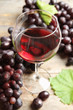 © New Africa - Glass of red wine and fresh ripe juicy grapes on table