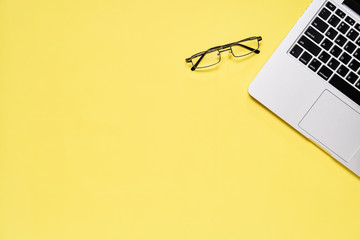 Fototapete - Top view, Modern workplace with laptop and glasses. placed on a pastel background. Copy space suitable for use in graphics.