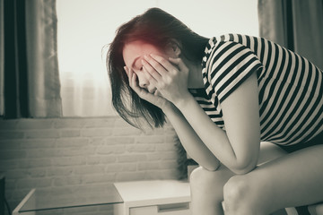 Young woman having a headache on bed.