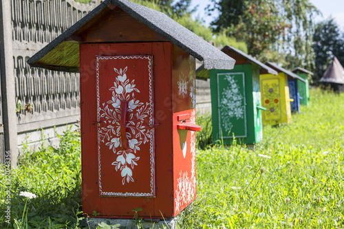 Fotografering Painted old wooden beehives decorated with a hand painted colorful floral motive