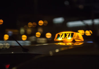 Wall Mural - illuminated sign taxi on the roof of the car at night