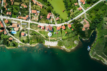 Wall Mural - aerial view of small village on a lake coast with calm clear water