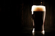 © 5ph - Dark english beer, ale or stout is poured into glass, dark bar counter, space for text, selective focus