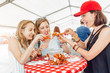 © EdNurg - Group of young multiracial girl friends eating seafood crab or crawfish at a outdoor restaurant