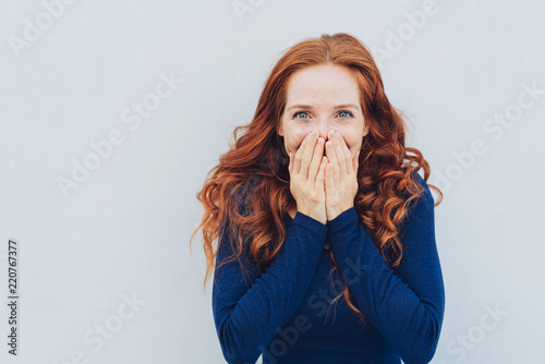 Cuadros en Lienzo Embarrassed young woman covering her face