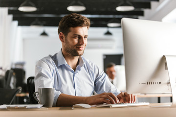 Canvas Print - Image of Smiling business man using computer