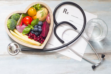 Wall Mural - Healthy food in heart stethoscope and medical prescription diet and medicine concept
