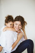 © Anton - Cute little daughter happily hugging beautiful mother while spen