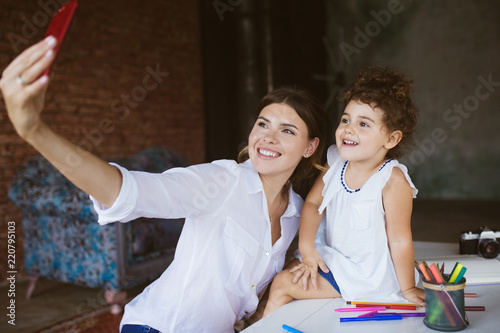 Fotografia Beautiful smiling mother and cute baby daughter happily taking p