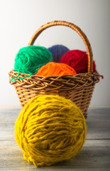 colored threads with a line of meters and a basket. on a light background and a wooden one