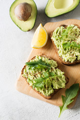 Two toasts with avocado and green salad on breakfast